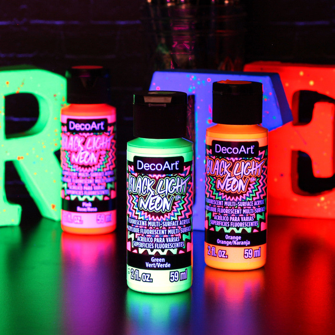 DecoArt Black Light Neon Paint Set showing vibrant neon paint bottles and brushes on a white background.